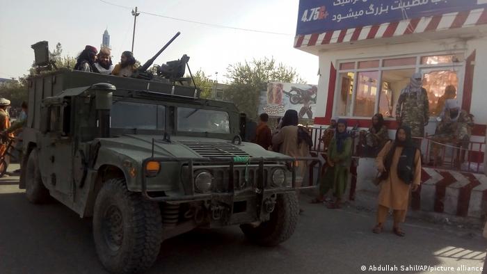 Taliban fighters and a military vehicle in Kunduz (photo: Abdullah Sahil/AP/picture-alliance)