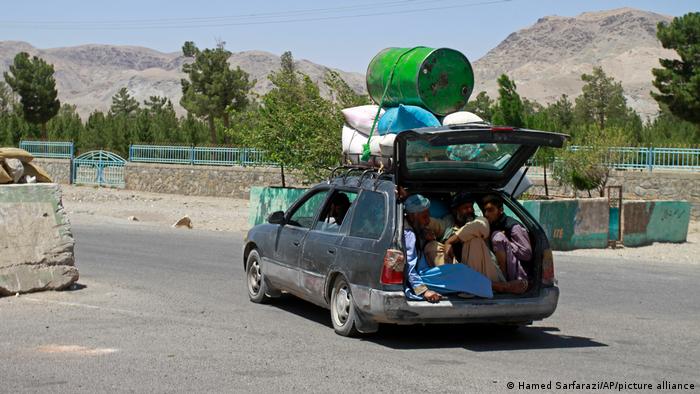 Station wagon with bedding and a barrel strapped to the roof and people in the hatch (photo: Hamed Sarfarazi/AP/picture-alliance)