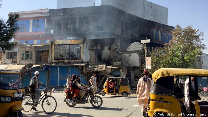 Busy street scene in Kunduz with damaged buildings, people and vehicles (photo: Abdullah Sahil/AP/picture-alliance)