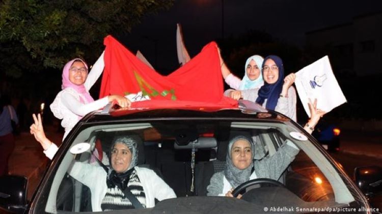 Supporters of Morocco's PJD (Justice and Development Party) in a car with flags (photo: Abdelhak Sennalepa/dpa/picture-alliance)