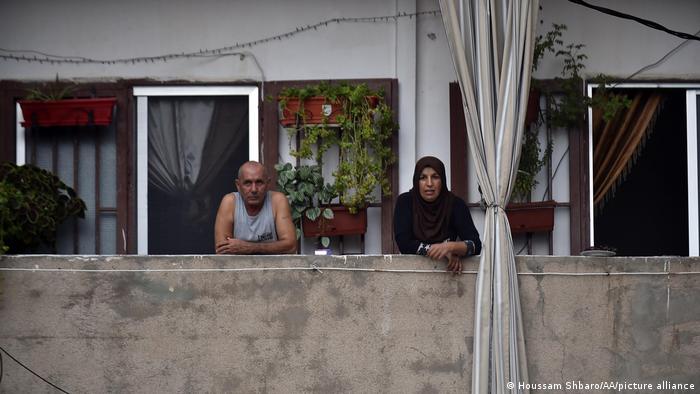 An elderly couple watch from their balcony in Beirut.