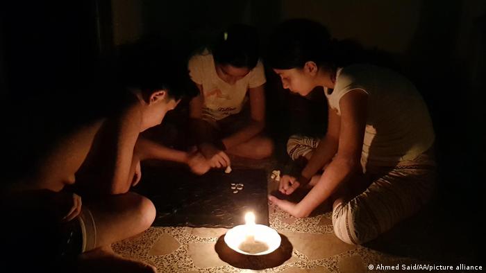 Children play a game by candlelight in Lebanon.