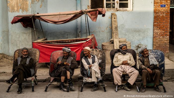Tagelöhner sitzen auf Stühlen am Straßenrand in Kabul und warten auf Anstellung.