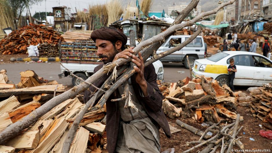 A vendor carries wood at a firewood market in Sanaa, Yemen, 17 July 2021 (photo: Reuters/Khaled Abdullah)