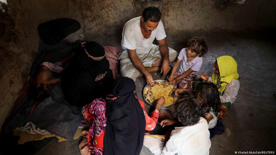 Ali al-Emadi, who works as a lumberjack, eats lunch with his family at their house in a village in Khamis Banisaad district of al-Mahweet province, Yemen, 24 June 2021 (photo: Reuters/Khaled Abdullah)
