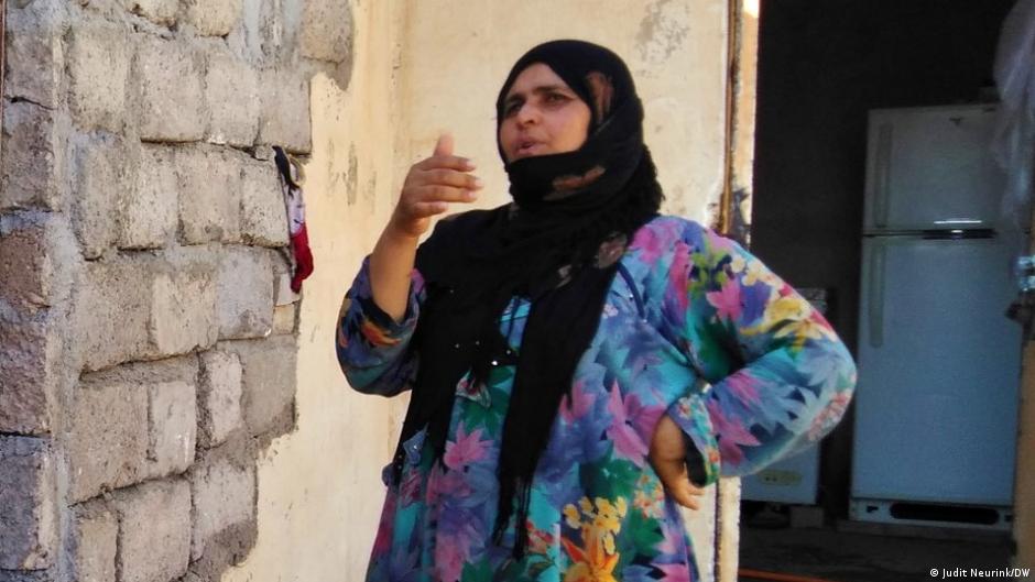 Eine Frau mit Kopftuch vor ihrem Haus in Mossul (Foto: Judit Neurink/DW)