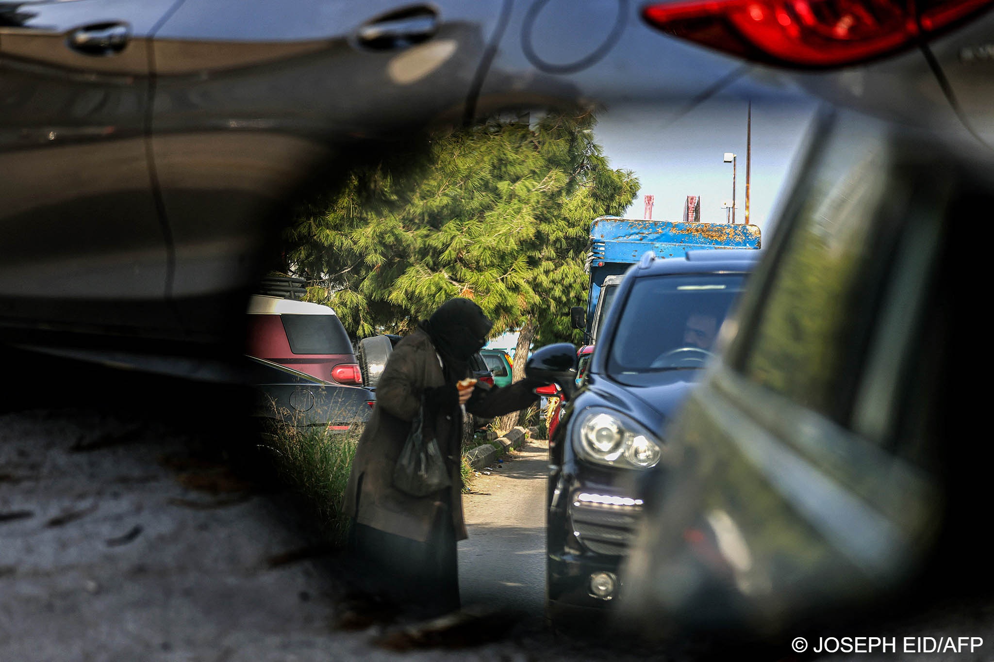  A woman begs a motorist for money in Beirut. Four out of five Lebanese are now considered poor, according to the UN income threshold of two dollars a day (photo: Joseph Eid/AFP) 