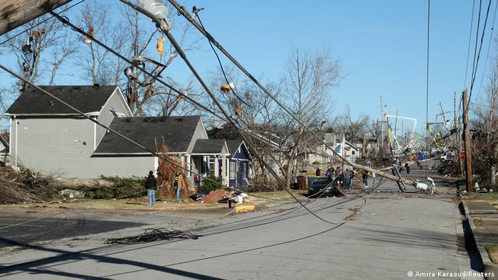 A street with uprooted trees and power lines