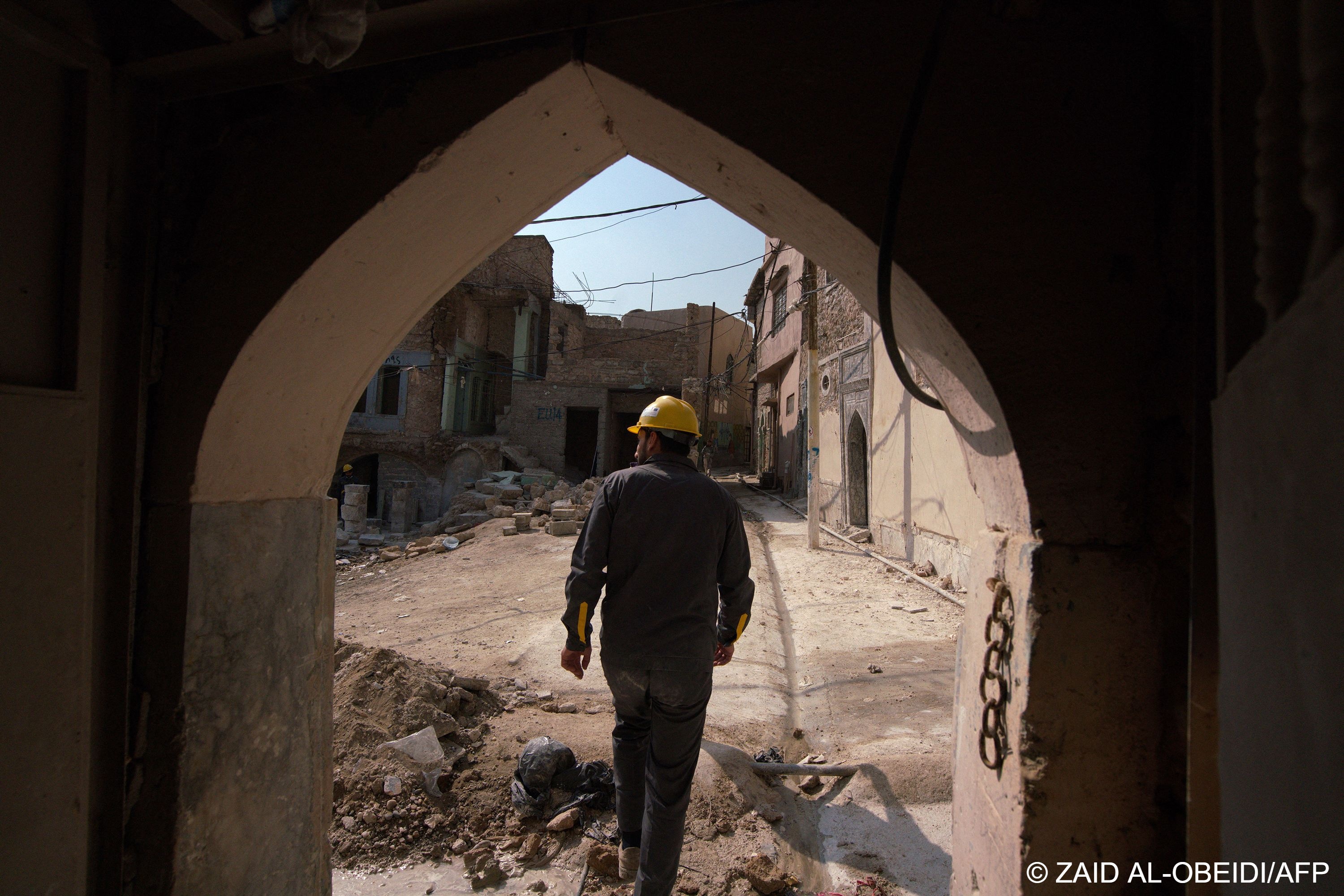 A picture shows an Iraqi architect exiting a traditional house amid renovations in the old town of Iraq‘s northern city of Mosul.