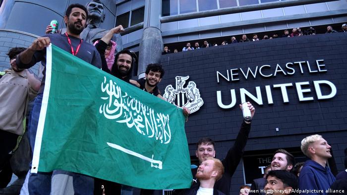 Newcastle United fans hold up a Saudi flag outside the stadium