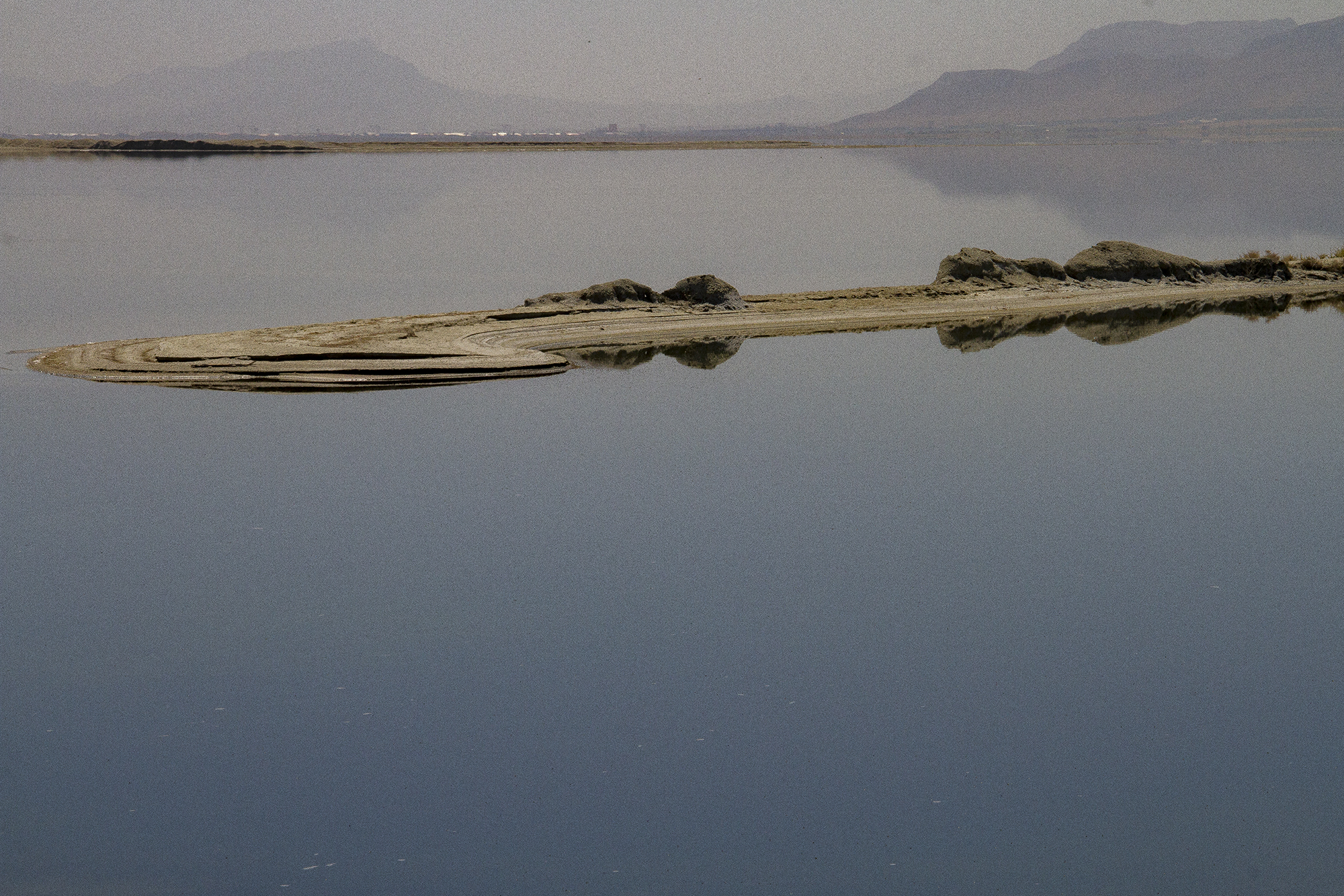 View of a lake, with mountains behind and an island in the middle distance (photo: Qantara)