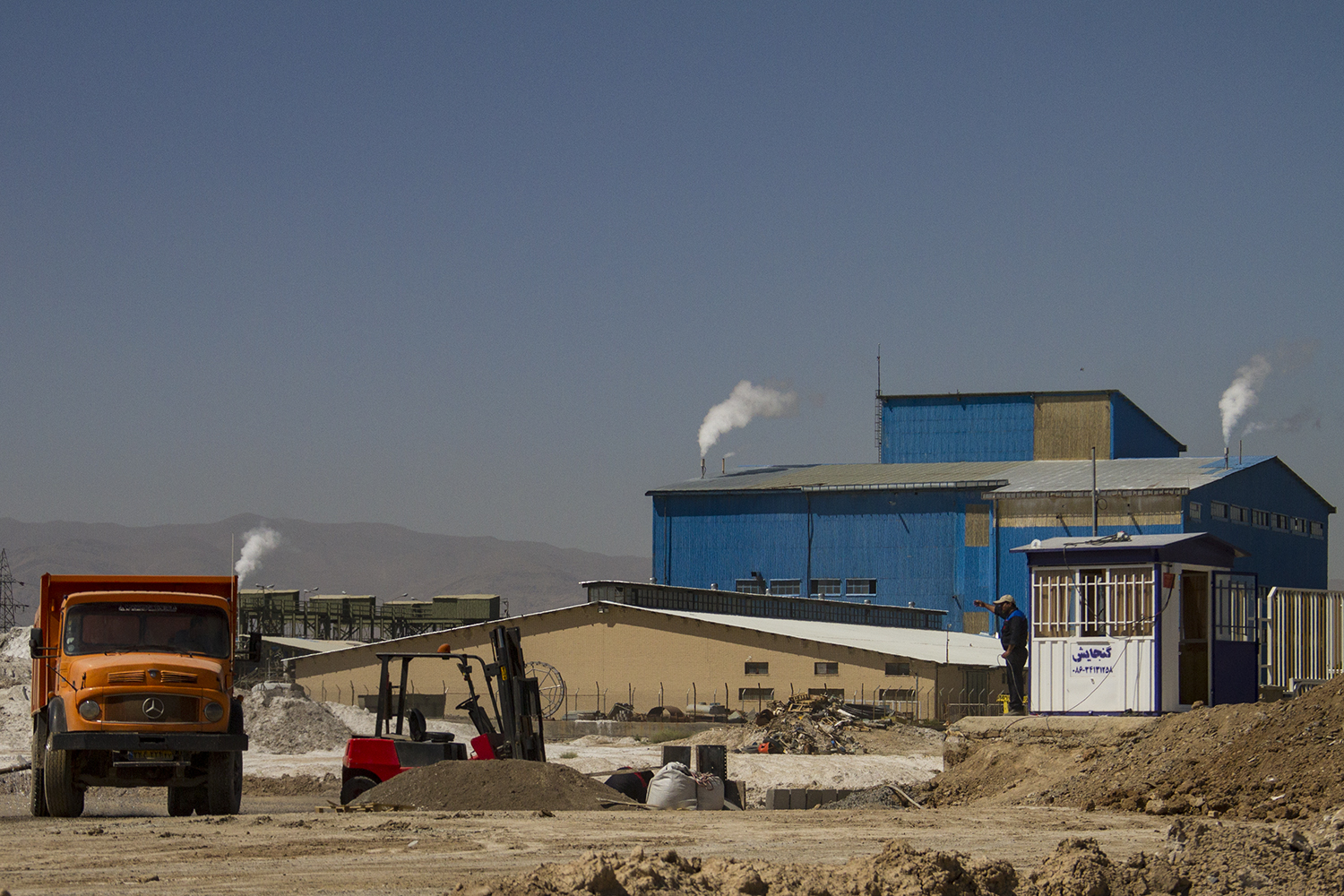 View of an industrial plant, arid foreground (photo: Qantara)