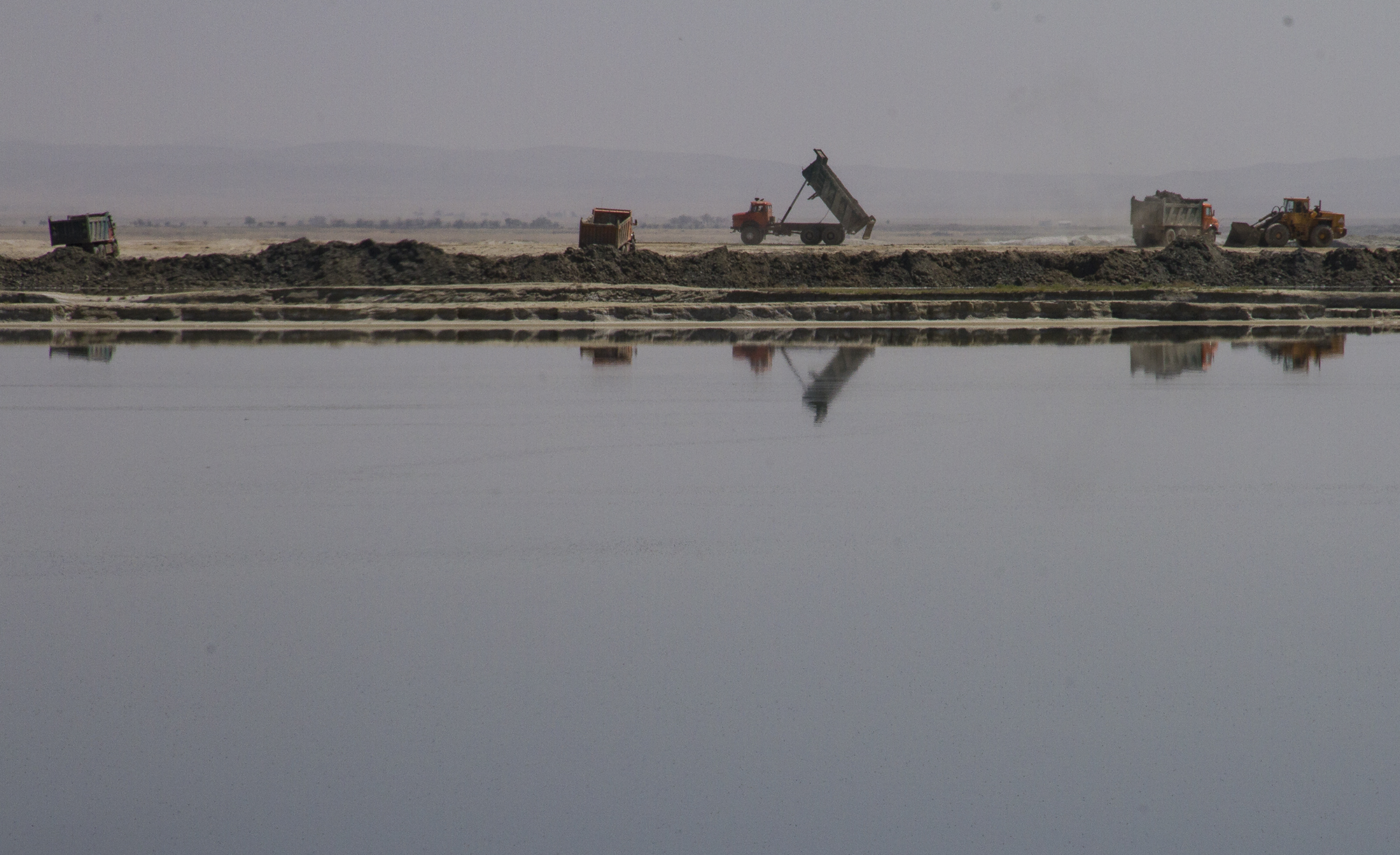 Far shore of lake with a distant excavator (photo: Qantara)
