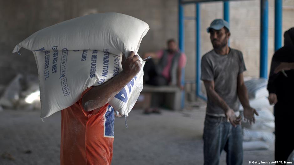 UNRWA-Mitarbeiter bei der Verteilung von Lebensmitteln; Foto: AFP/S. Khatib