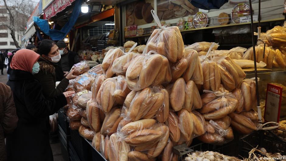امرأتان عند مخبز في سوق في أنقرة - تركيا - ديسمبر  / كانون الأول 2021. Women shop for bread at a market in Ankara, December 2021 (photo: Adem Altan/AFP) 