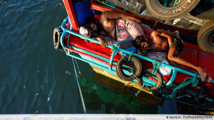 Fishermen sleeping on the deck of a trawler in Negombo, 16 April 2022 (photo: Reuters/Navesh Chitrakar)