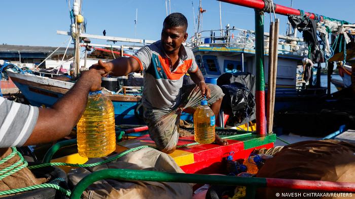 Men trade petrol containers for their boats, Sri Lanka, 16 April 2022 (photo: Reuters/Navesh Chitrakar) 