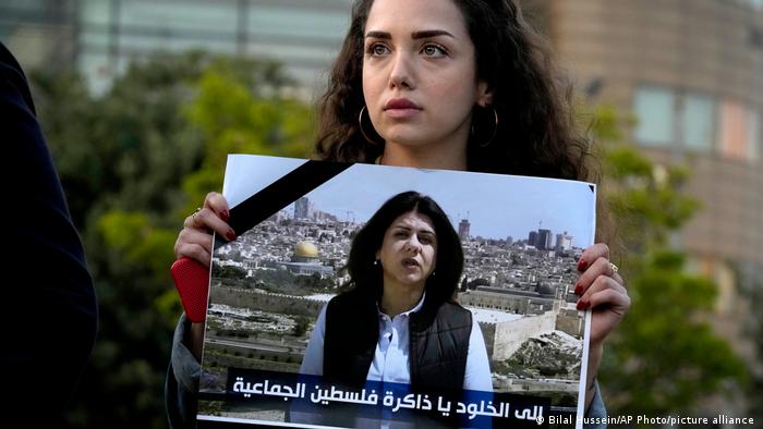 A Lebanese journalist holds a portrait of Al Jazeera journalist Shireen Abu Akleh