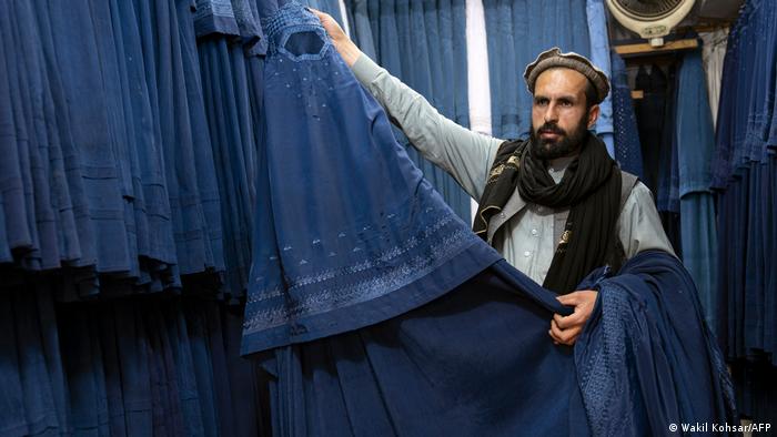 A burka trader in Kabul presents his wares
