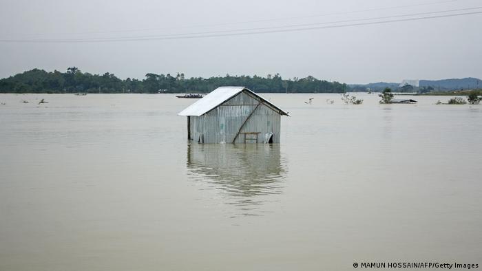 A house on the banks of the Surma River is completely surrounded by water