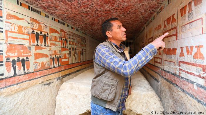 An archaeologist points at the mural painting in an ancient tomb uncovered at Saqqara archaeological site southwest of Cairo, Egypt, on 19 March 2022