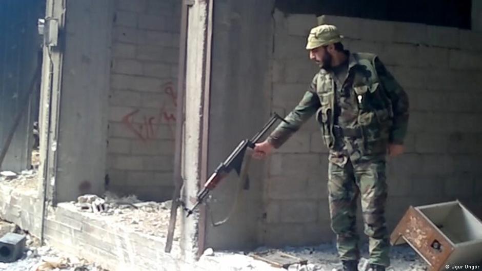 لقطة فيديو لضابط مخابرات سوري يطلق النار. Video still of a Syrian intelligence officer shooting into a pit (photo: Ugur Umit Ungor)