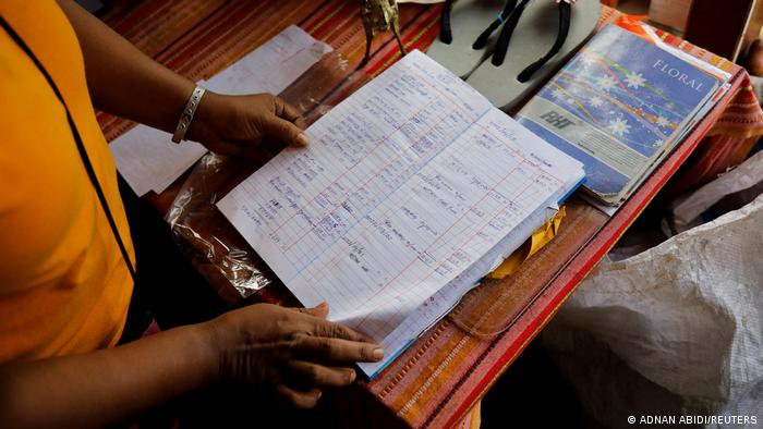 Lasanda Deepthi takes a look at her expense book (photo: REUTERS/Adnan Abidi)