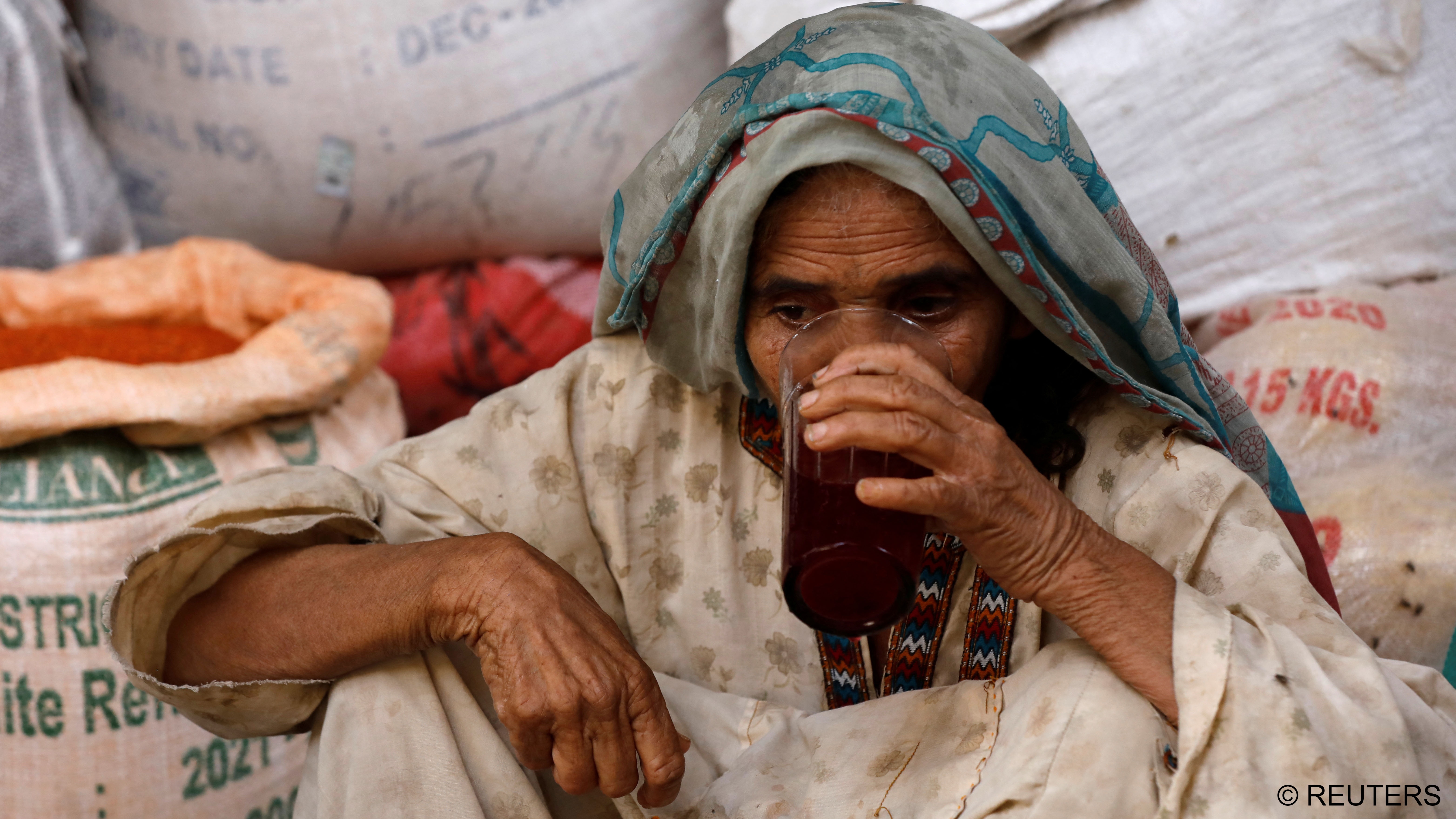 A woman drinks a plum and tamarind drink to cool off (photo: Reuters/Akhtar Soomro)