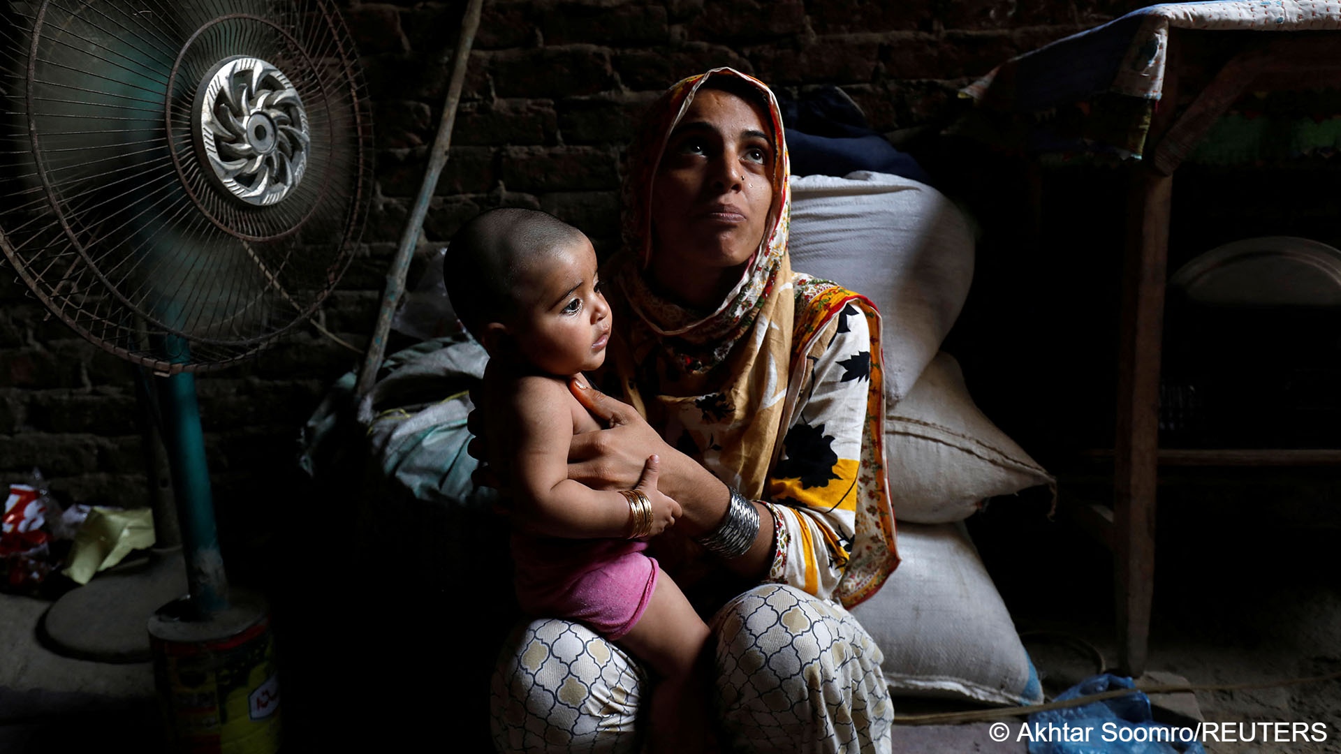 Young mother Razia attempts to cool her six-month-old baby down (photo: Reuters/Akhtar Soomro)