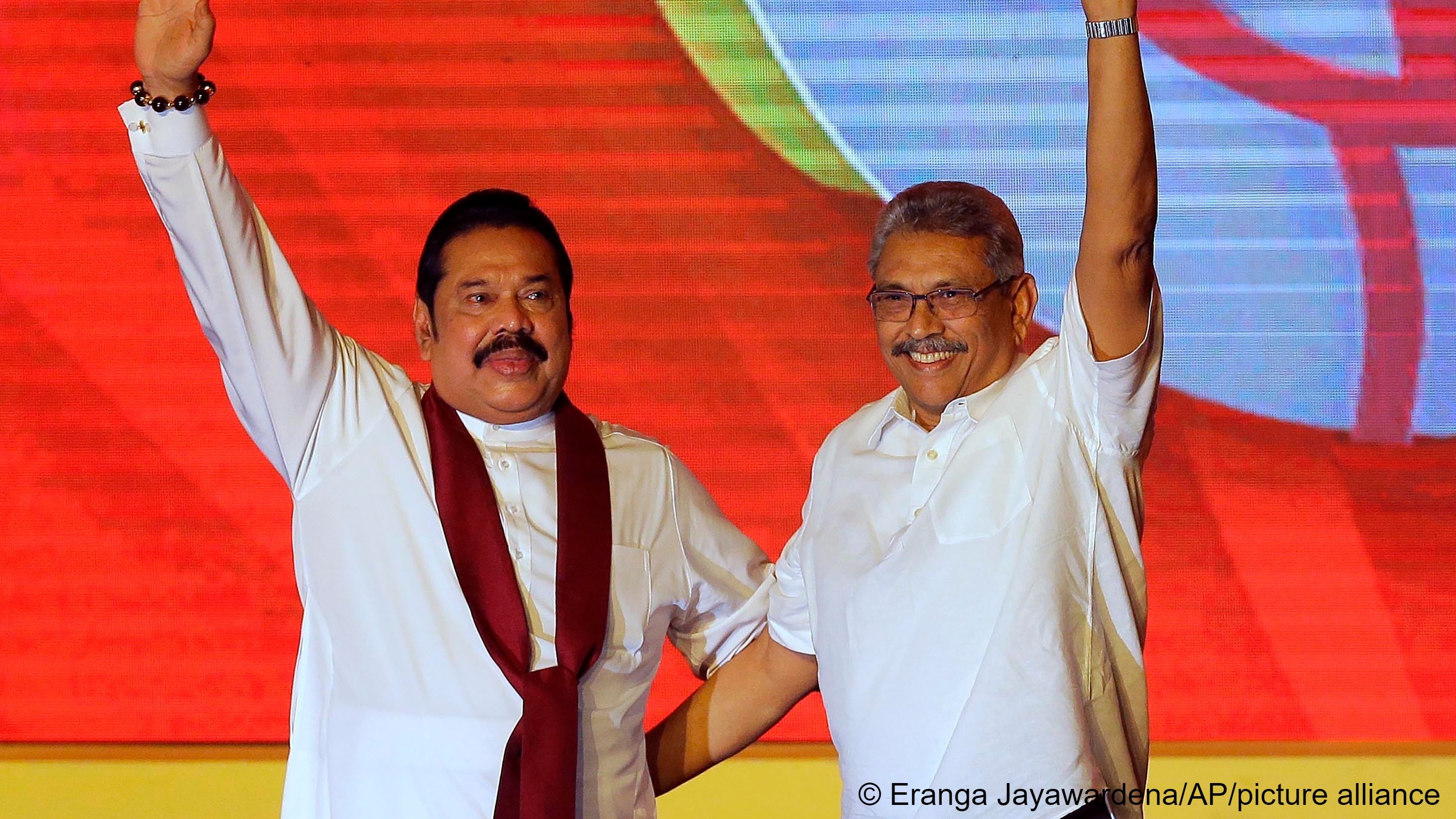 Mahinda Rajapaksa, left, and his brother Gotabaya Rajapaksa wave to supporters during a party convention held to announce Gotabaya's presidential candidacy in Colombo, Sri Lanka, 11 August 2019 (photo: AP Photo/Eranga Jayawardena)