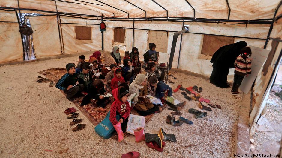 People gather inside a tent at a amp for internally displaced persons in Idlib, Syria (photo: AFP/Getty Images)