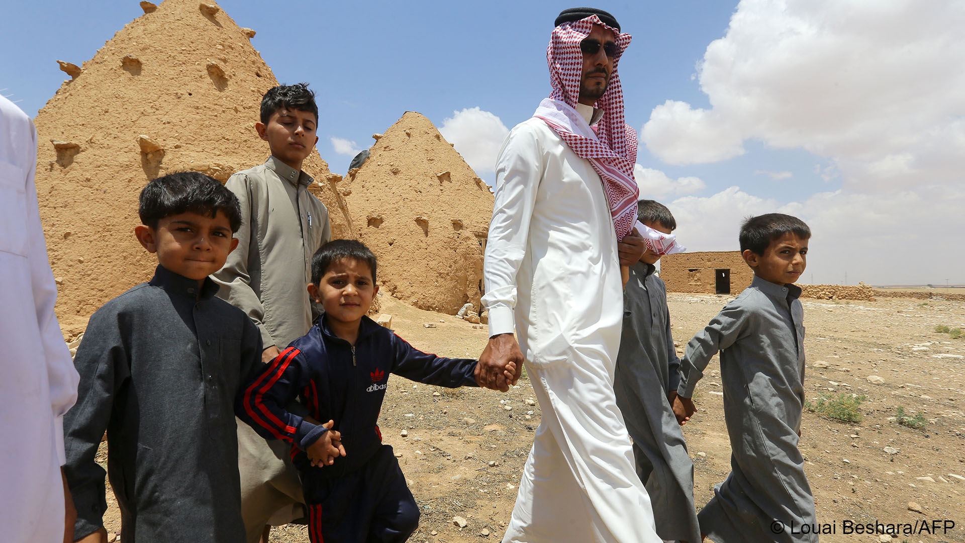  Abdulaziz al-Oqab walks with with his nephews who were orphaned when a landmine exploded under a pick-up truck, claiming the lives of 21 family members.