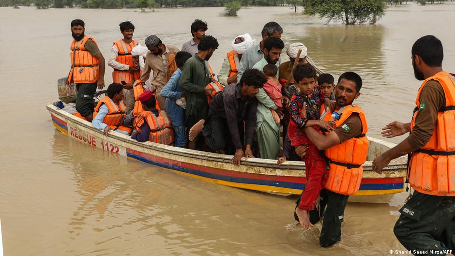 Rescue workers help evacuated flood affected people in Rajanpur district of Punjab province on 27 August 2022