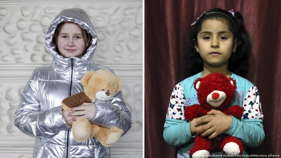 Ein Mädchen aus der Ukraine mit ihrem Teddybär und ein Mädchen aus Syrien mit ihrem Kuscheltier (Foto: AA/picture-alliance)