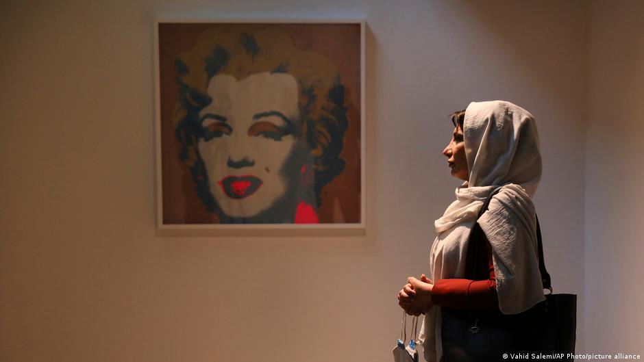 Woman looks at Warhol painting of Marilyn Monroe (photo: AP Photo/picture-alliance)