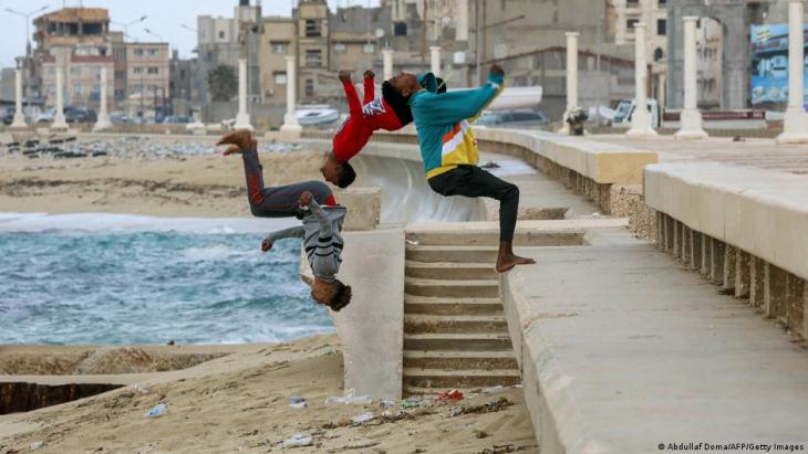 Boys backflip onto the sand in Libya (photo: Getty Images)