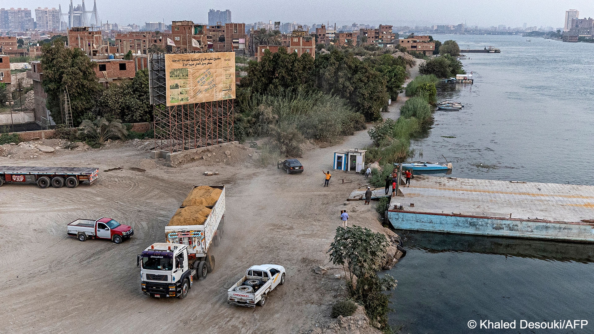 A trailer truck filled with sand waits near a dock at the construction site of new residential towers in the Nile island of Warraq in Giza province opposite the northern shore of Egypt‘s capital on August 31, 2022, the slums of which are planned for development by the Egyptian government (photo: AFP)