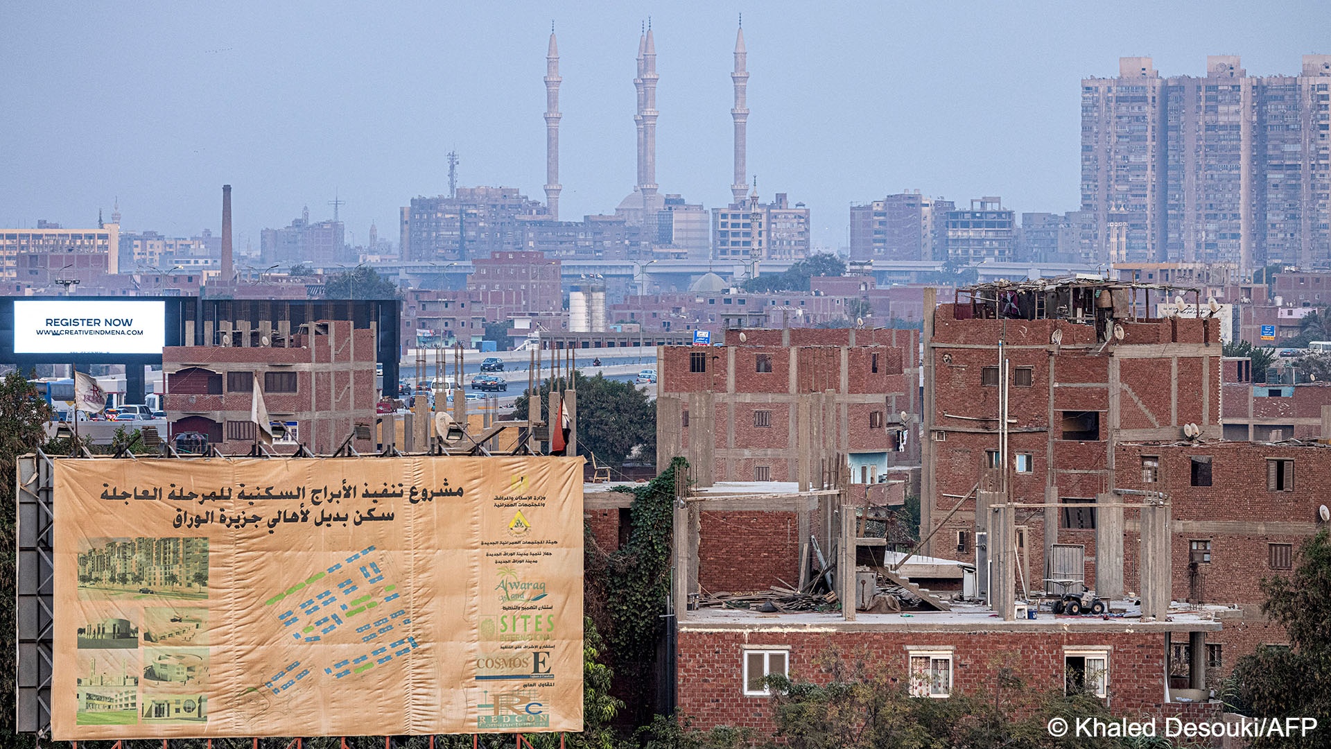 This picture taken on August 31, 2022 shows a construction billboard announcing the site of new „alternative accommodation“ residential towers as part of the government development plans of the slums of the Nile island of Warraq, opposite Cairo‘s northern shore (photo: AFP)
