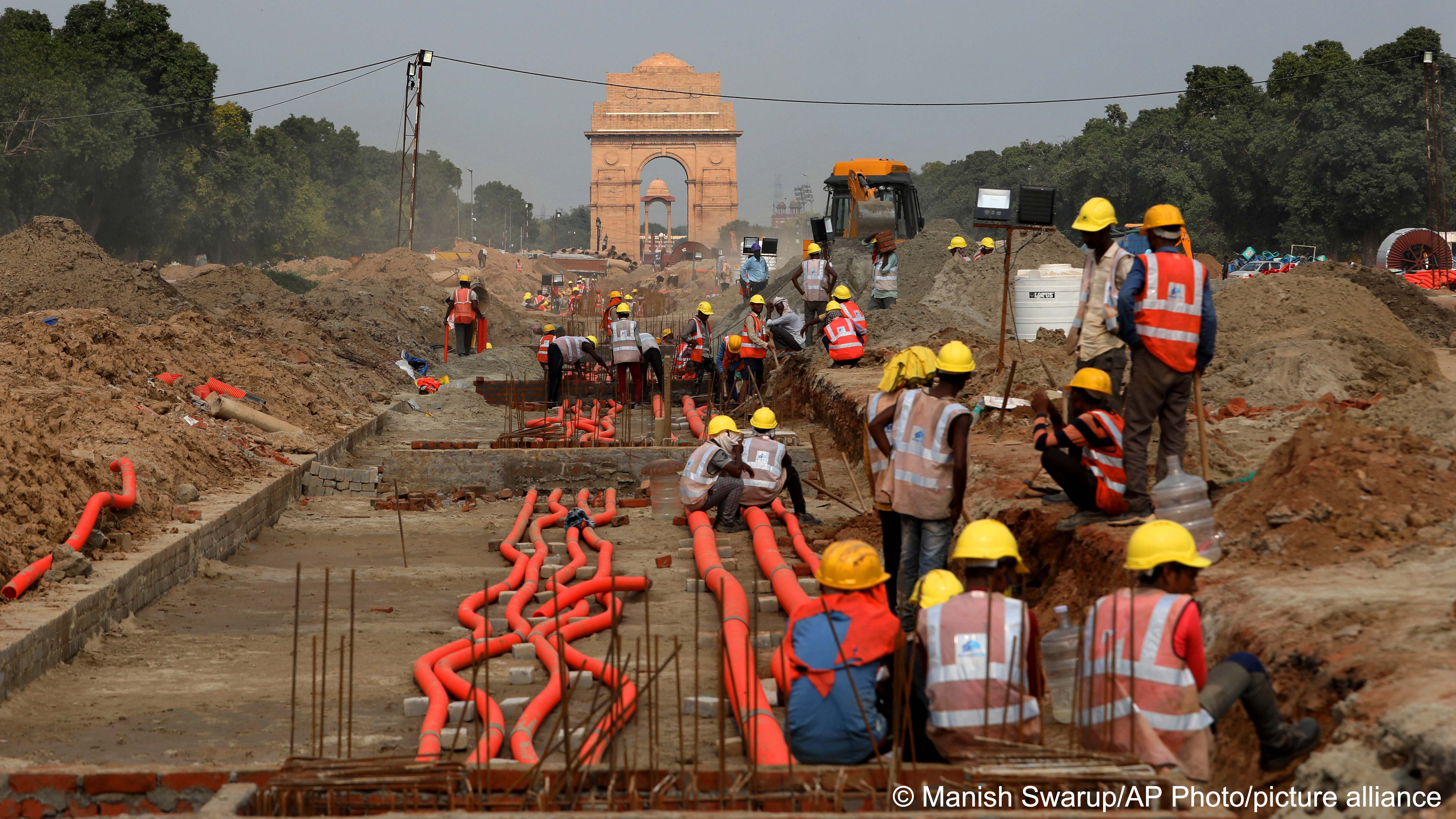 India Gate monument is seen behind as laborers work on the Central Vista project in New Delhi, India, 16 July 2021 (photo: AP Photo/Manish Swarup)