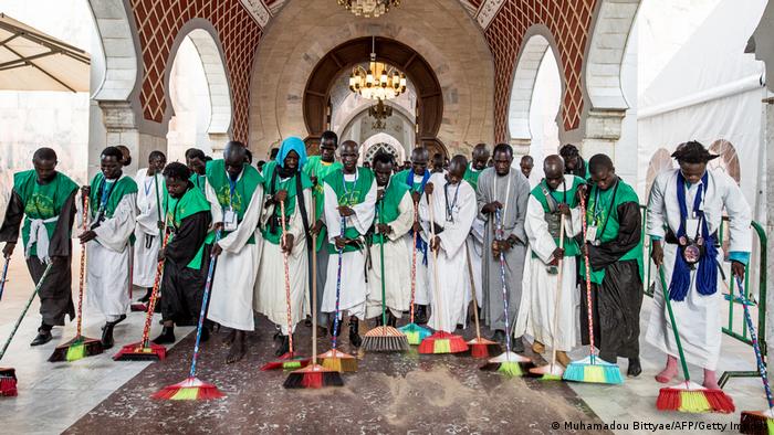 Members of the Mouride brotherhood sweep the floors of the Great Mosque of Touba