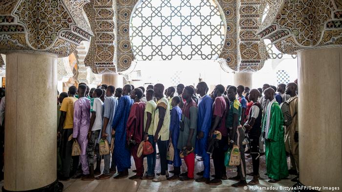 Faithful Muslims stand in lines waiting to enter the Great Mosque of Touba