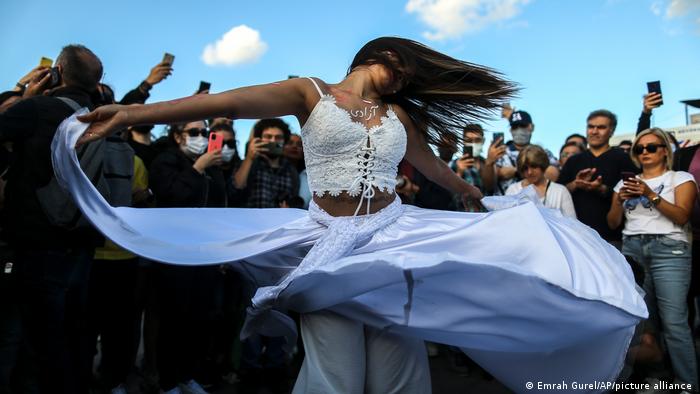 Woman dances with loose hair and flowing white skirt
