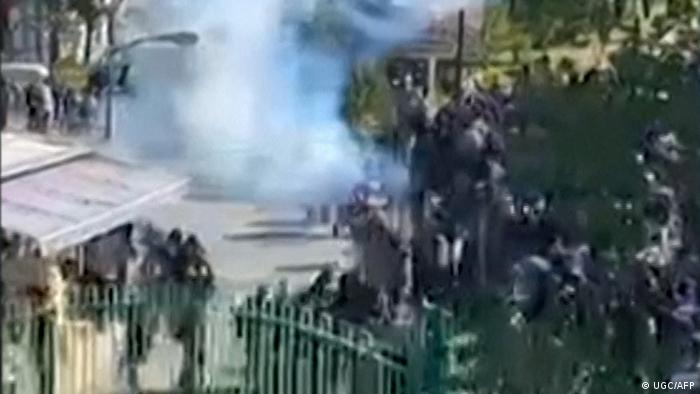 Blurred image of protests on university campus grounds in Tehran