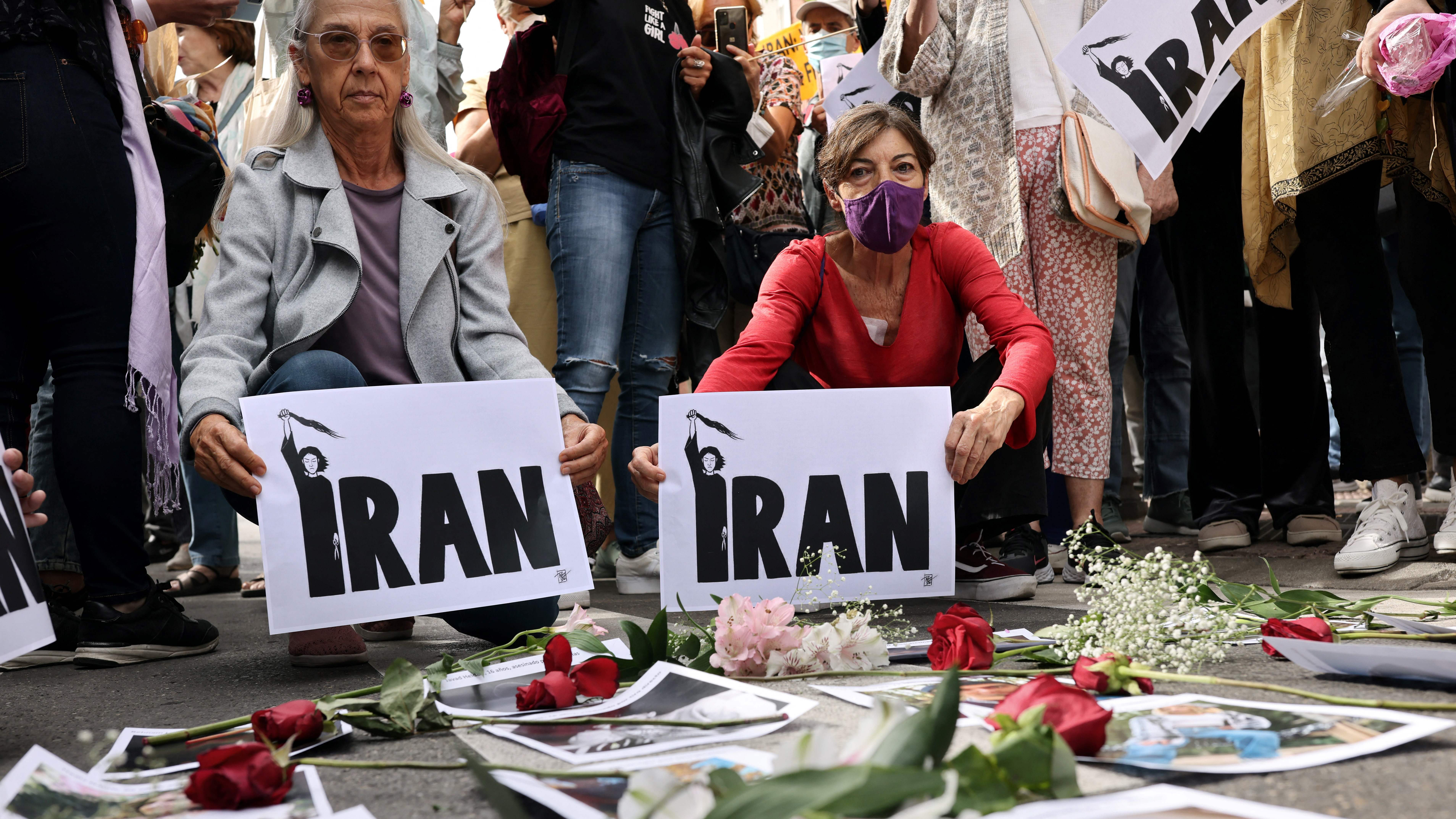 Demonstrators display flowers on pictures of victims during a protest in front of the Iranian embassy in Madrid, on 28 September 2022 (photo: THOMAS COEX/AFP/Getty)