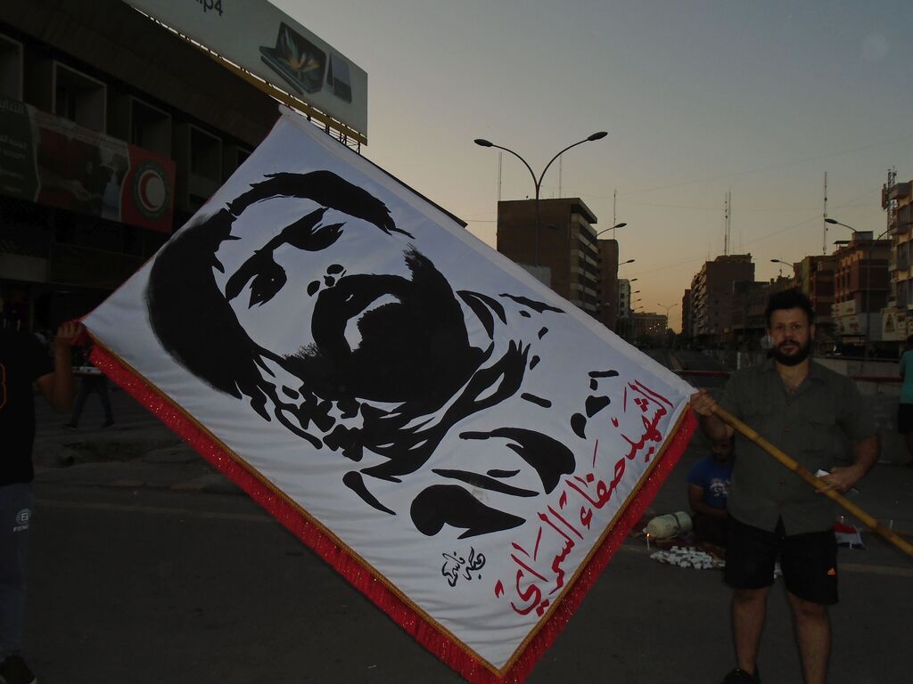 Alaa from Baghdad demonstrates with his flag on Tahrir Square (photo: Birgit Svensson)