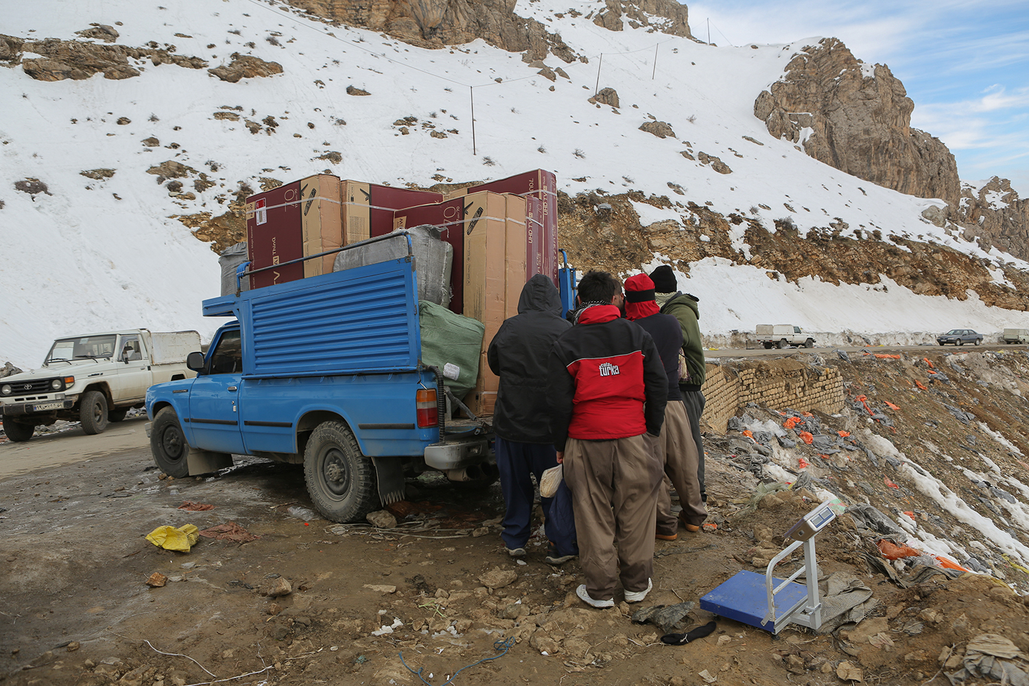 Men gather around the back of a van, unloading their packs (photo: Konstantin Novakovic)