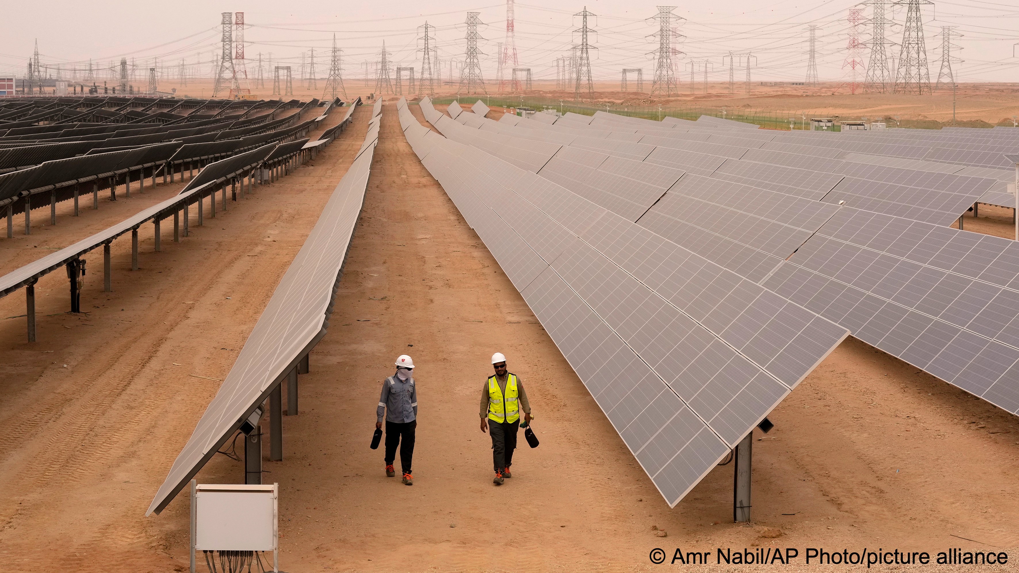 Engineers walk next to solar panels at Benban Solar Park, one of the world’s largest solar power plant in the world, in Aswan, Egypt, Wednesday, 19 October 2022 (photo: AP Photo/Amr Nabil)