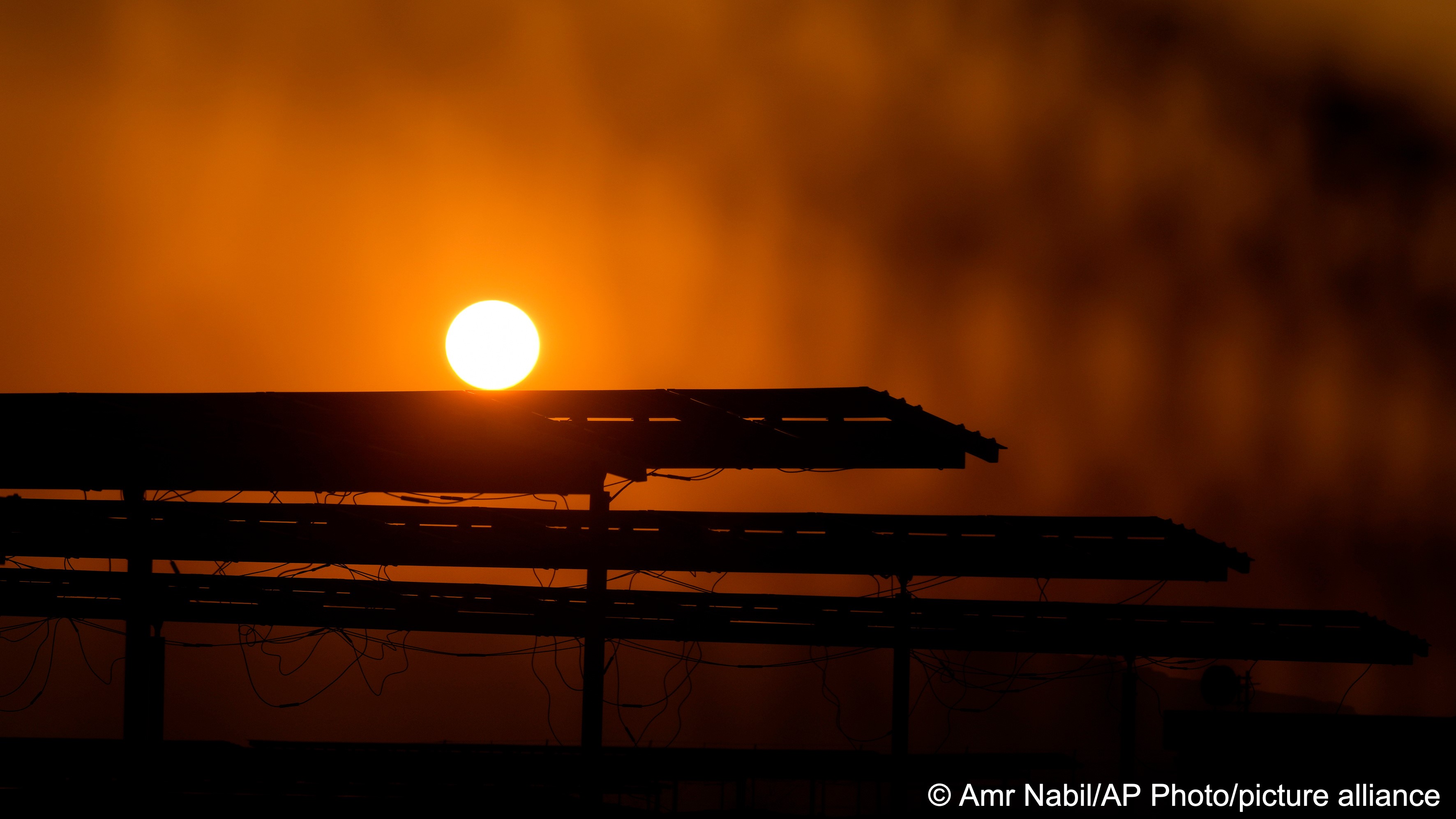 The sun sets behind photovoltaic solar panels at Benban Solar Park, one of the world’s largest solar power plant in the world, in Aswan, Egypt, 19 October 2022 (photo: AP Photo/Amr Nabil)