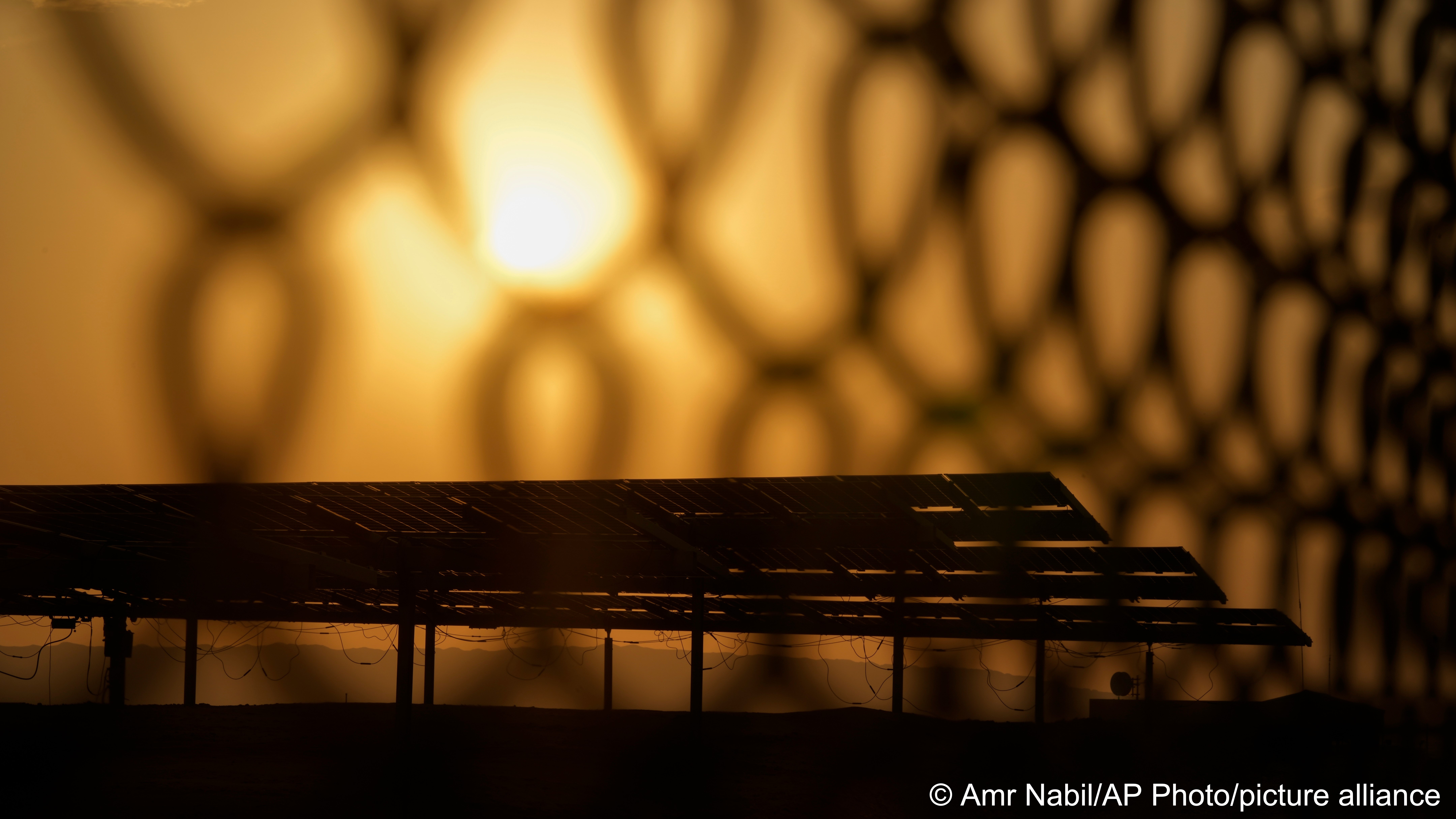 The sun sets behind photovoltaic solar panels at Benban Solar Park, one of the world’s largest solar power plants in the world, in Aswan, Egypt, 19 October 2022 (photo: AP Photo/Amr Nabil)