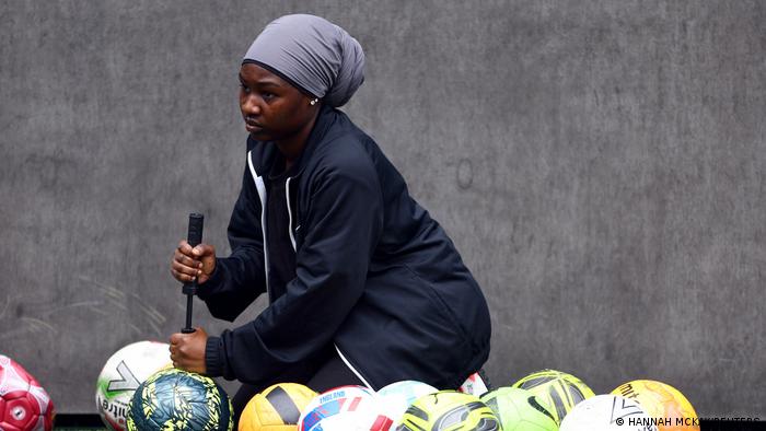 Jannat Ssetuba, 21, pumps up footballs during a Sisterhood FC training session. 